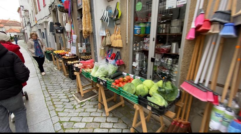 Mesa com frutas e verduras em frente a um comércio em fundão